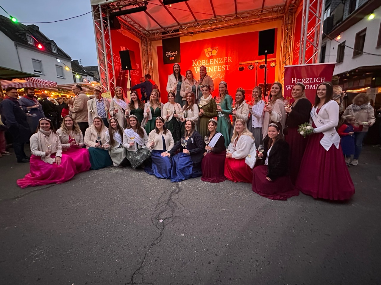 Gruppenbild zahlreicher Weinmajestäten vor der Weinfestbühne