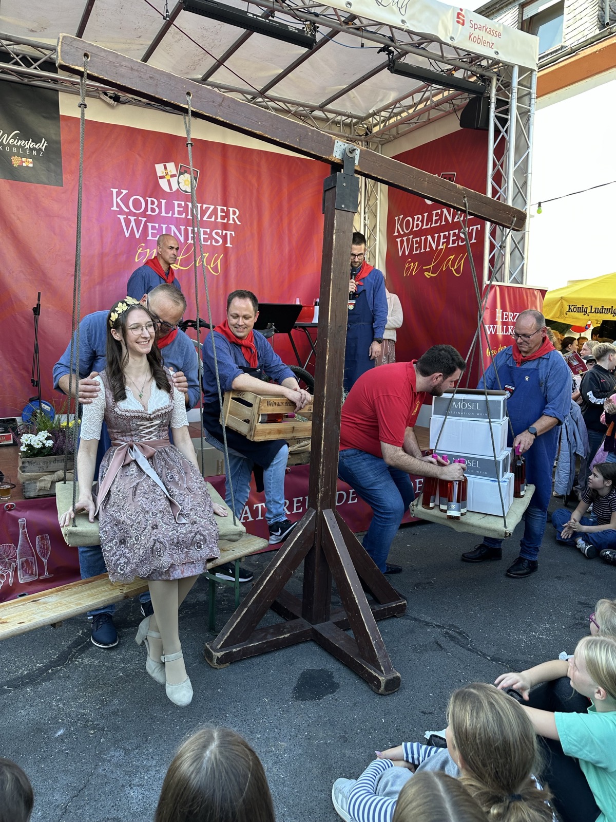 Weinmajestät auf der historischen Weinwaage beim Weinfest in Lay